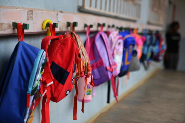 Colorful backpacks hung up on rack
