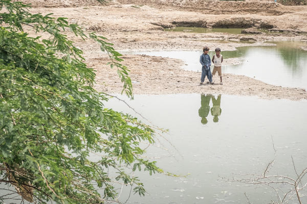 Children standing near flooded grounds