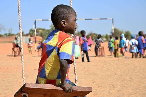 Boy sitting on swing looking away