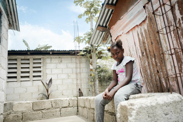 girl in Haiti sitting on bench