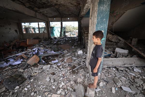 Palestine student standing in rubble of destroyed school