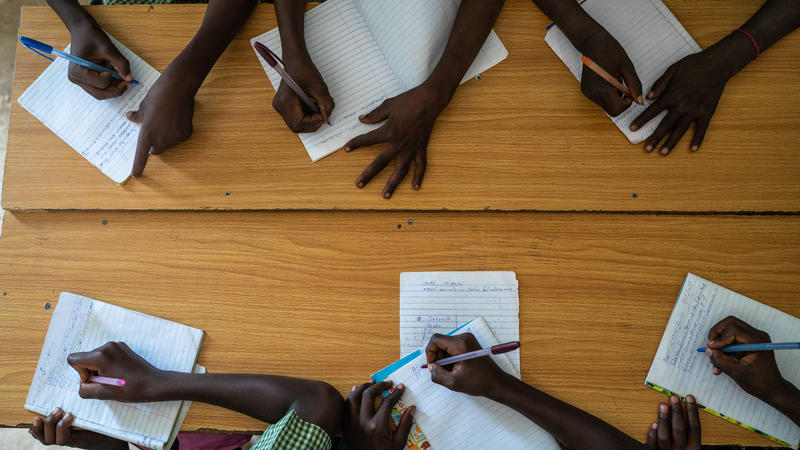 Students hands writing at table