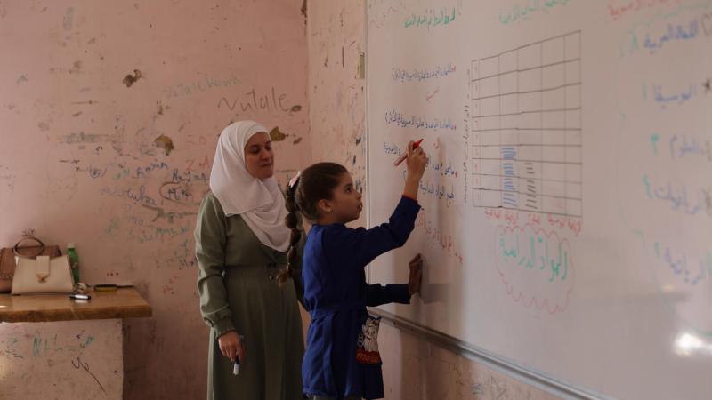 girl in Syria writing on whiteboard